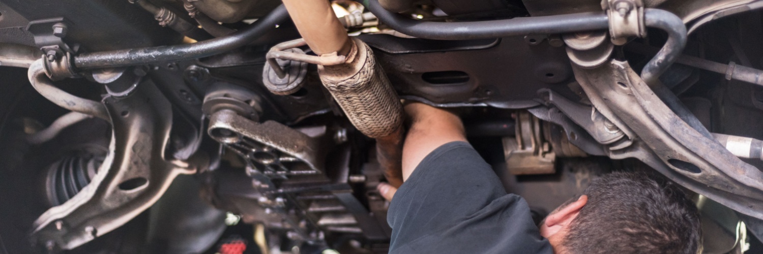 mechanic maintaining exhaust system